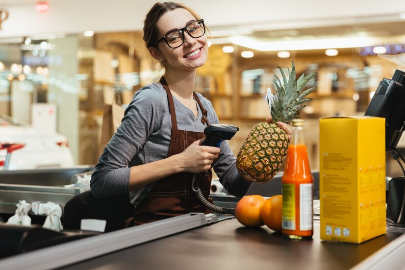 Happy Female Cashier Scanning Grocery Items — commercial security installed by KSEDCO across Georgia